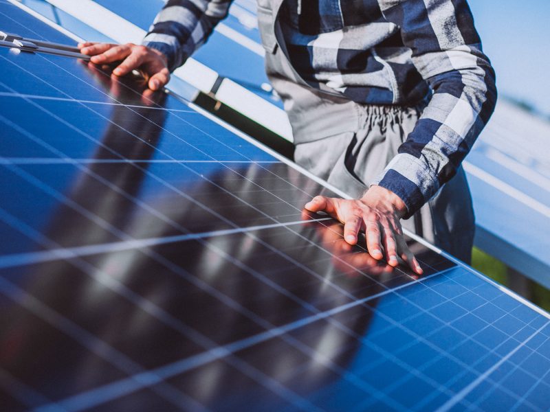 Man worker in the firld by the solar panels Man worker in the firld by the solar panels